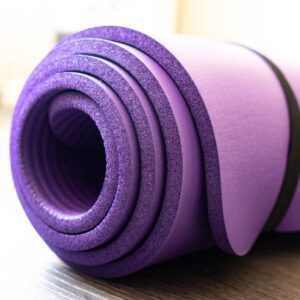 Mat for yoga and fitness on the floor. side view. healthy lifestyle concept.