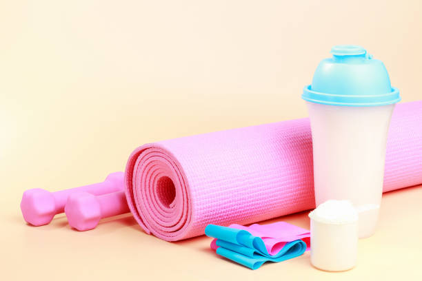 Sports accessories and protein shake on a brown background close up.
