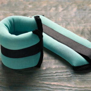Turquoise ankle weights on light blue wooden table