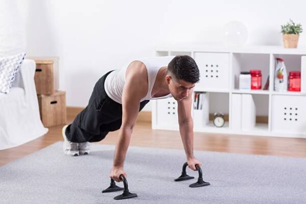 Attractive bodybuilder doing push ups in room